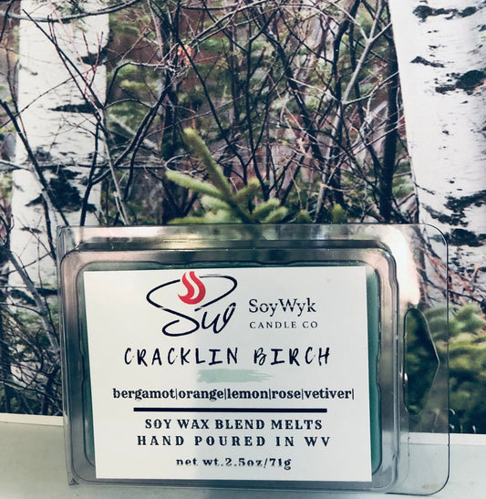 White Soy Wax Melt in a 2.5 oz clear package. Wax Melt in the woods with birch trees behind them. Labeled as “Cracklin Birch Featured fragrant notes are bergamot, orange, lemon, rose, vetiver. 
Hand-poured in WV by SoyWyk Candle Co. 