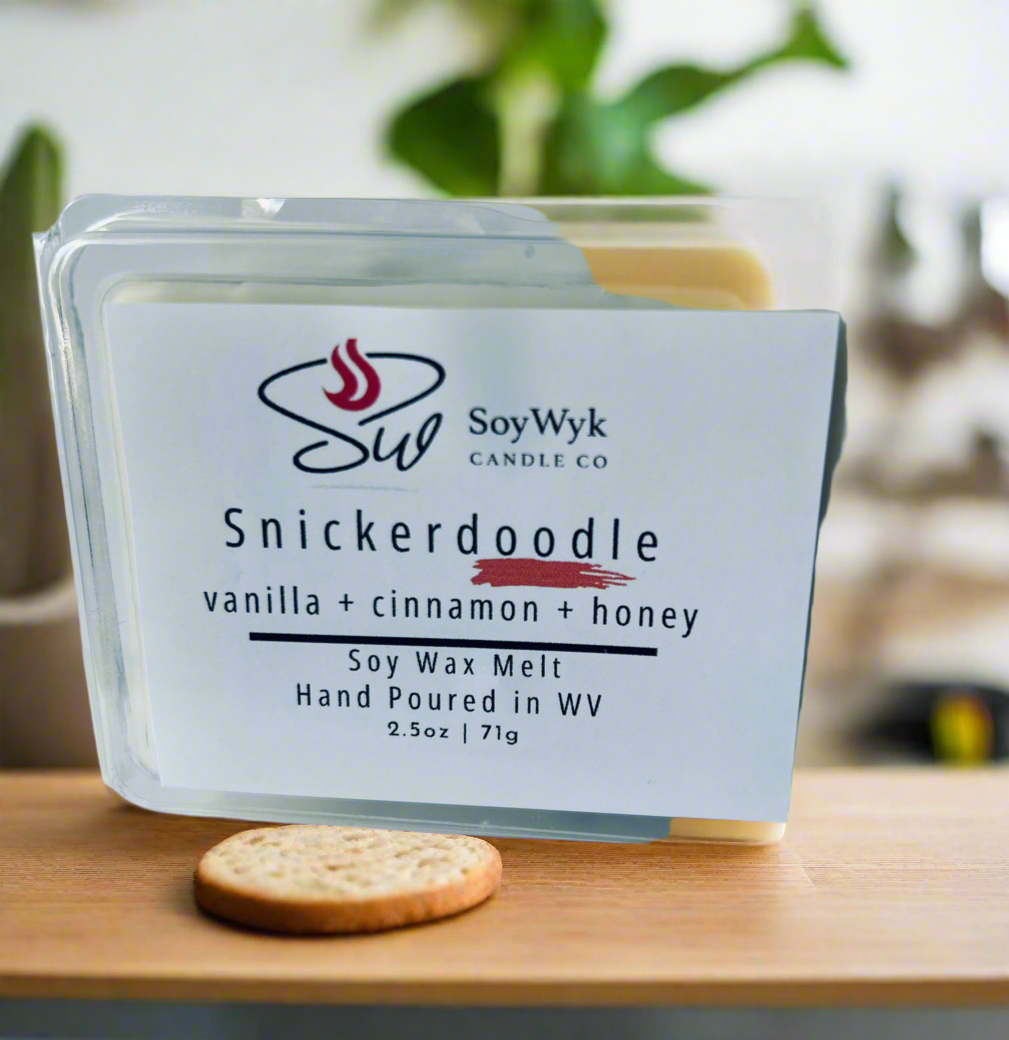 White Soy Wax Melt in a 2.5 oz clear package in a kitchen on a modern kitchen counter with plants. Labeled as “Snickerdoodle”.  Featured fragrant notes are  vanilla, cinnamon, and honey. 
Hand-poured in WV by SoyWyk Candle Co. 