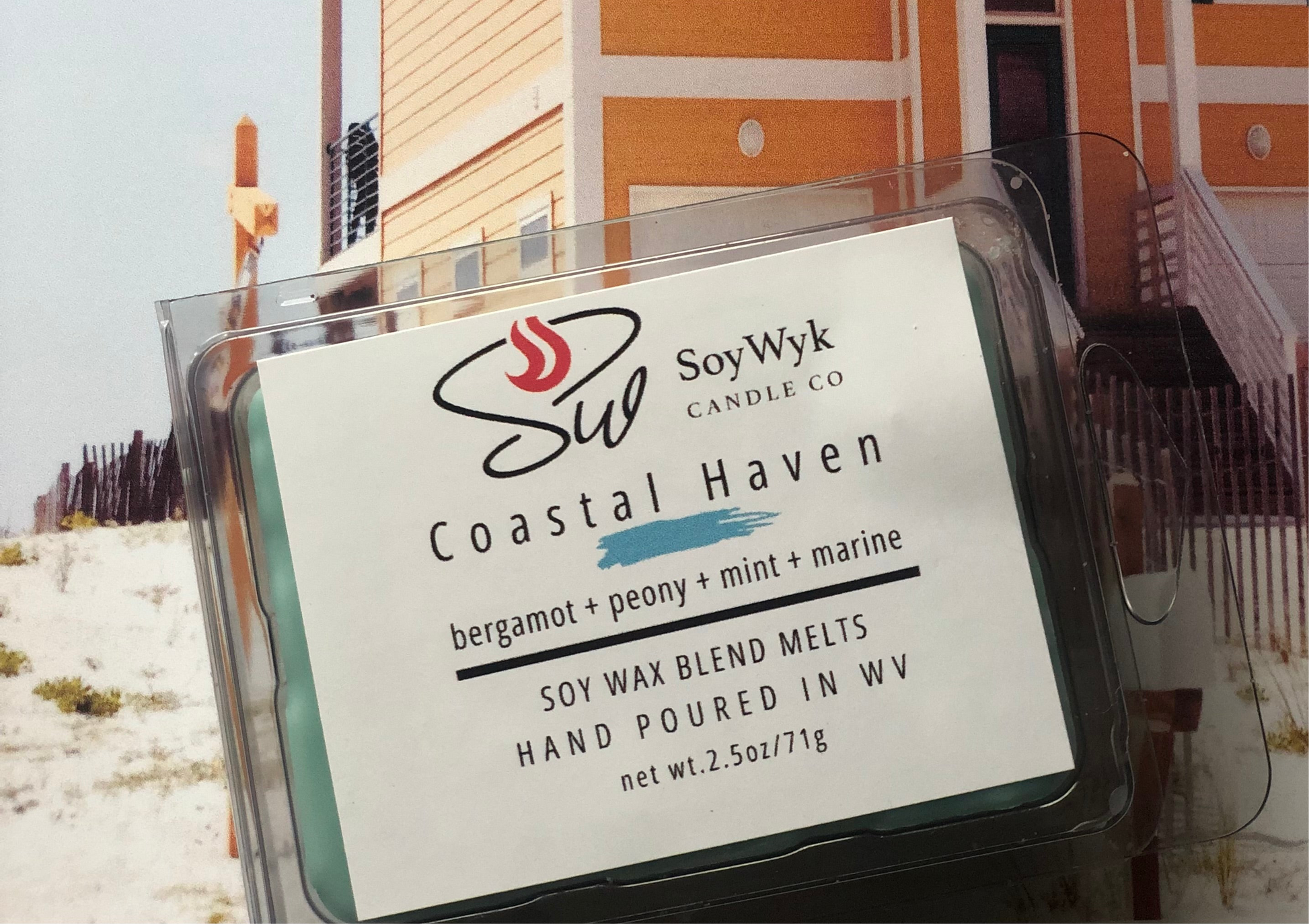 
Teal Soy Wax Melt in a 2.5 oz clear package along the coast of the beach in front of a light melon colored beach house. Labeled as “Costal Haven. Featured fragrant notes are bergamot, peony, mint, marine notes. 
Hand-poured in WV by SoyWyk Candle Co. 