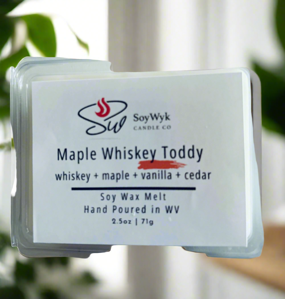 White Soy Wax Melt in a 2.5 oz clear package in a kitchen on a modern kitchen by a window with plants. Labeled as “Maple Whiskey Toddy” Featured fragrant notes are  whiskey, maple, vanilla, cedar. 
Hand-poured in WV by SoyWyk Candle Co. 
