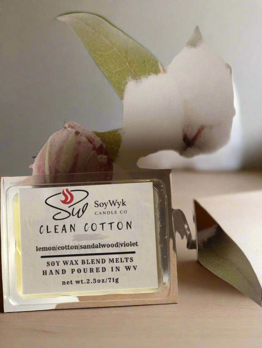 White Soy Wax Melt in a 2.5 oz clear package in the middle of white cotton on beige surface. Labeled as “Clean Cotton”.  Featured fragrant notes are lemon, cotton, sandalwood, violet. 
Hand-poured in WV by SoyWyk Candle Co. 