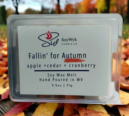 White Soy wax melt in a 2.5 oz clear package labeled “Fallin for Autumn “on a fall inspired background with fall leaves and trees. Featured fragrant notes are apple, cedar, cranberry. Hand-poured in WV by SoyWyk Candle  Co. 